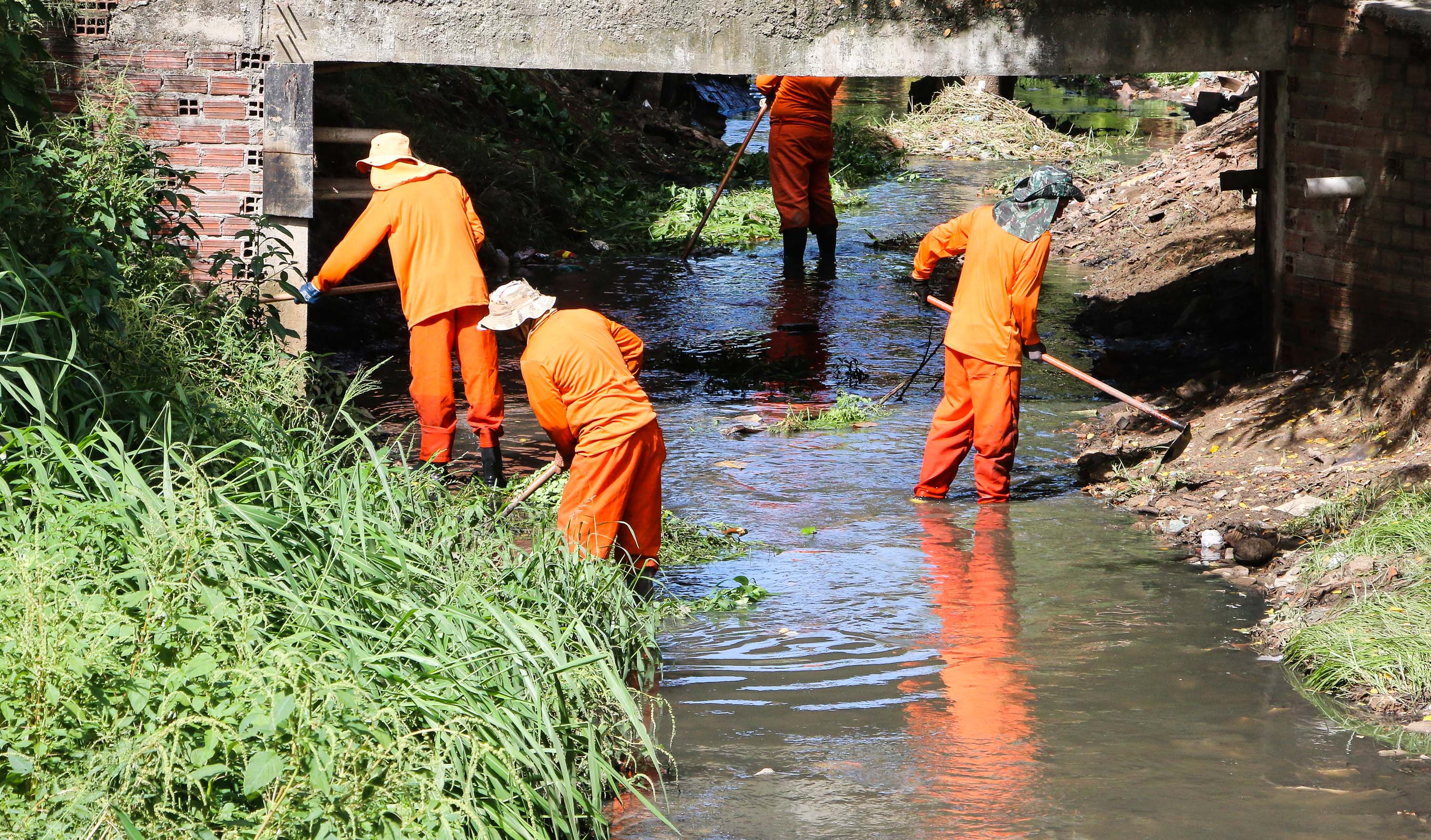 homens limpando um canal